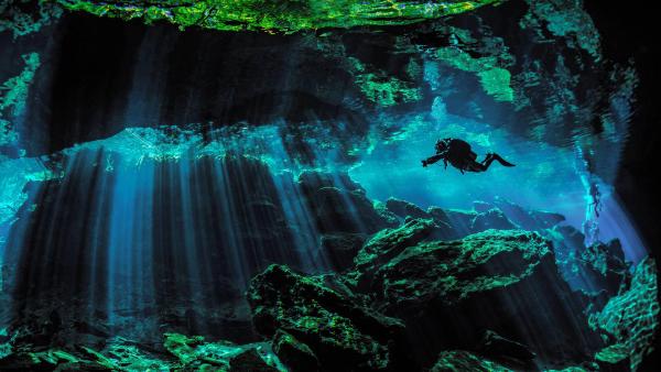 Scuba diver exploring the underwater cenotes near Puerto Aventuras, Mexico (©