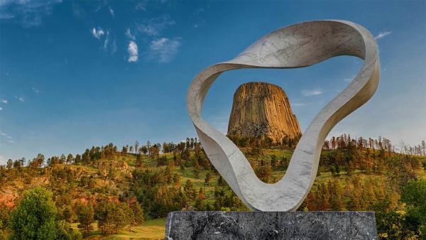 The 'Circle of Sacred Smoke' sculpture by Junkyu Muto frames Devils Tower in
